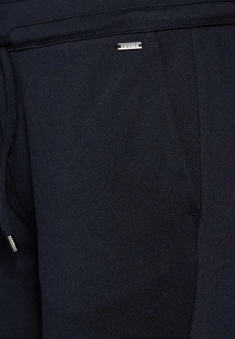 Nahaufnahme einer dunkelblauen Stoffhose mit sichtbarer Tasche.